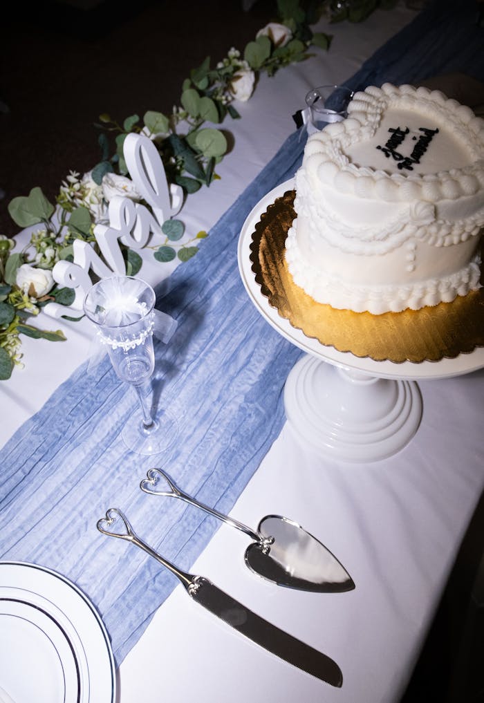 A wedding cake on a table with a knife and fork